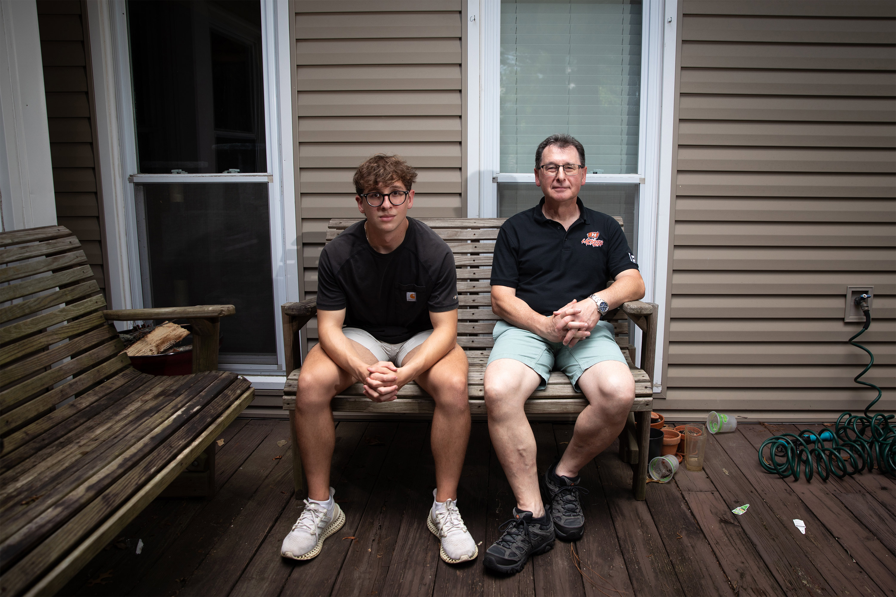 A photo of a teenager sitting next to his father.