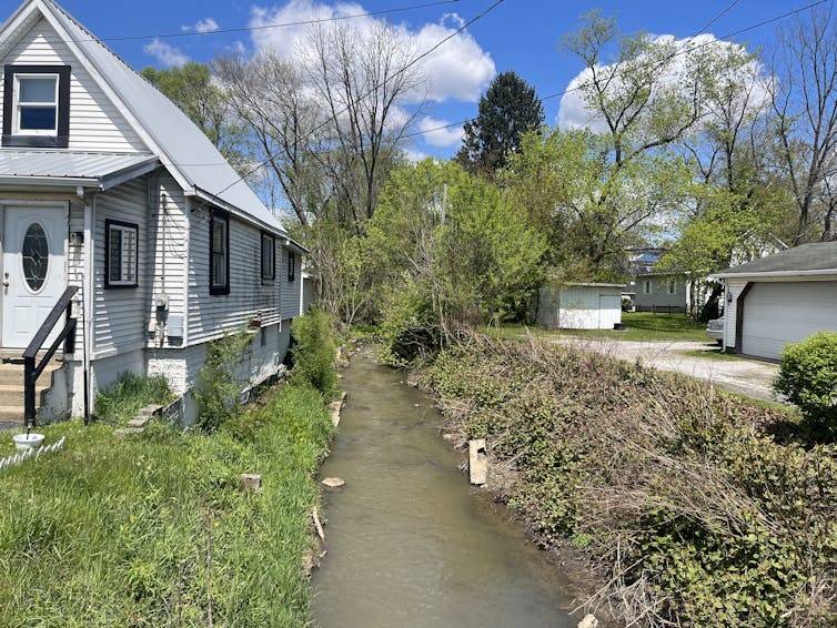 A homes sits alongside a contaminated creek.