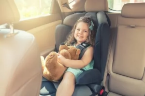 little girl sitting in the back of a car