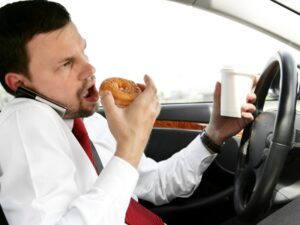 Distracted driver eats and takes calls while on the road