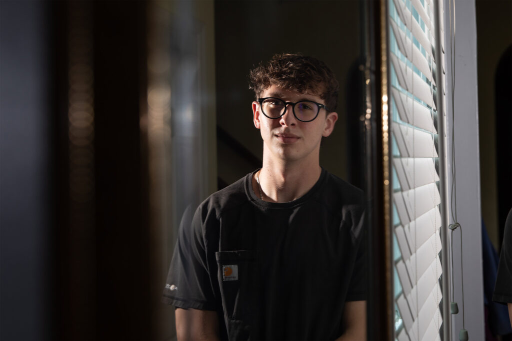 A photo of a teenager standing indoors for a portrait.