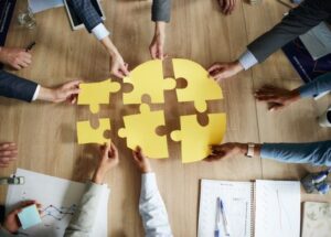 Businesspeople connecting puzzles in the office, symbolizing business synergies