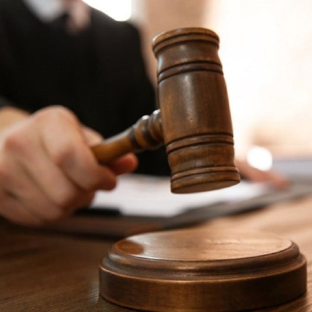 A judge holding a gavel in a court room