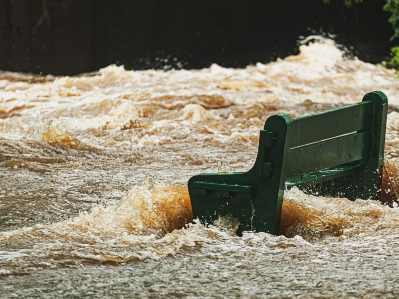 Park bench engulfed by flood waters